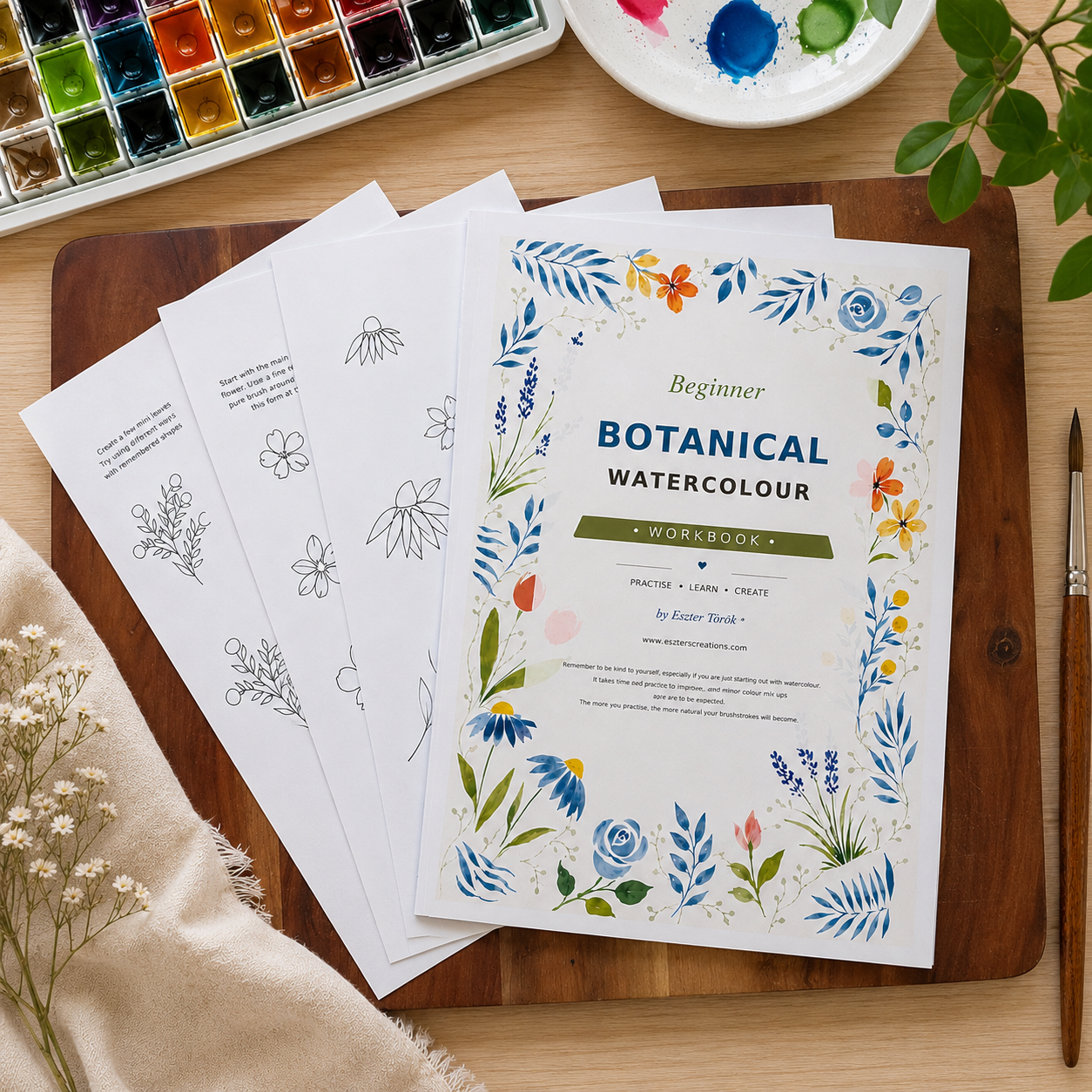 A watercolor painting workbook titled 'Beginner Botanical Watercolour' displayed on a wooden cutting board with other printed pages, a watercolor palette, a paintbrush, and dried flowers.