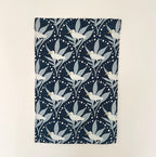 Navy blue cotton tea towel with white egret and leaf pattern on a beige background