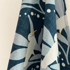 Cotton tea towel with bird and leaf pattern on a white background