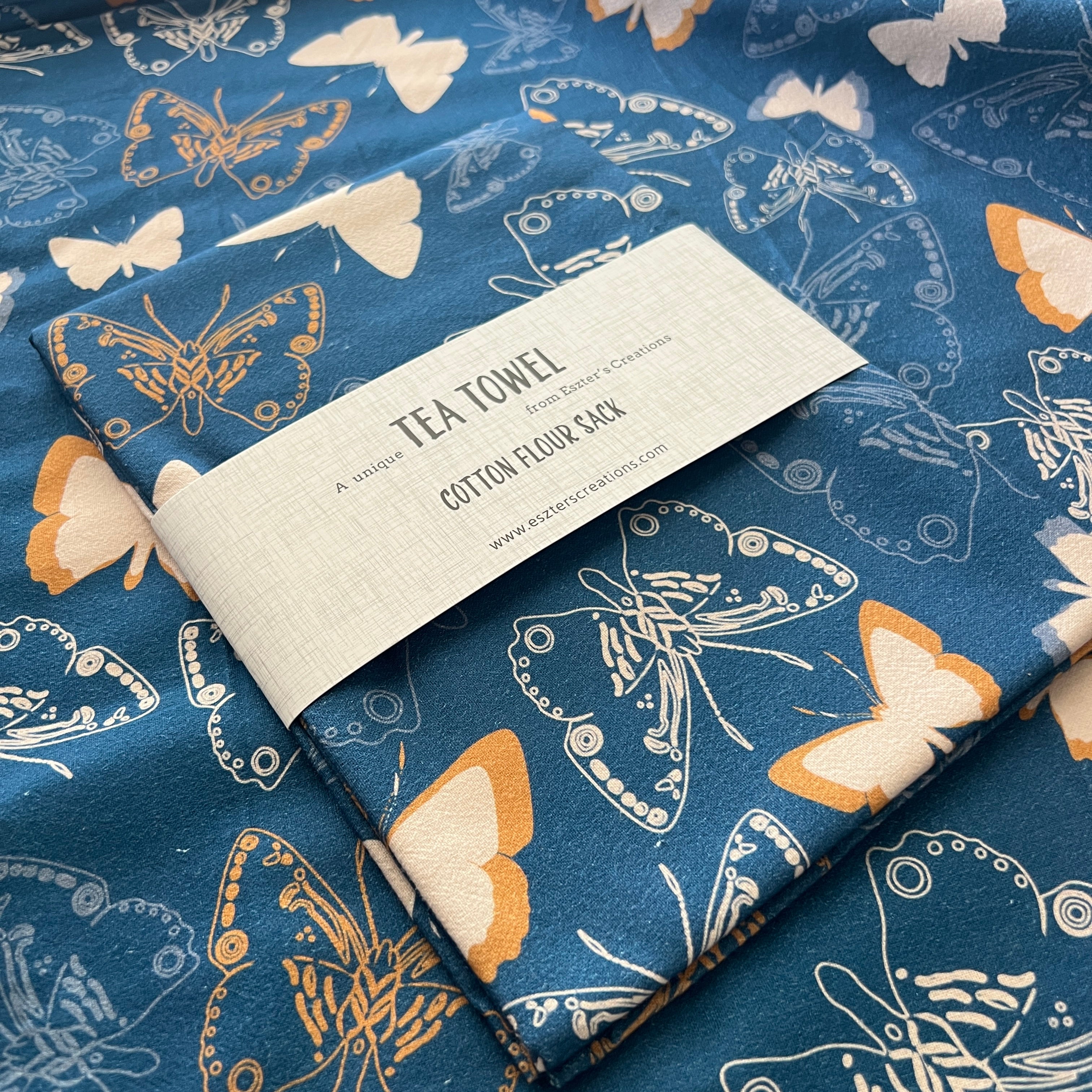 Tea towel with butterfly pattern and label on a blue background