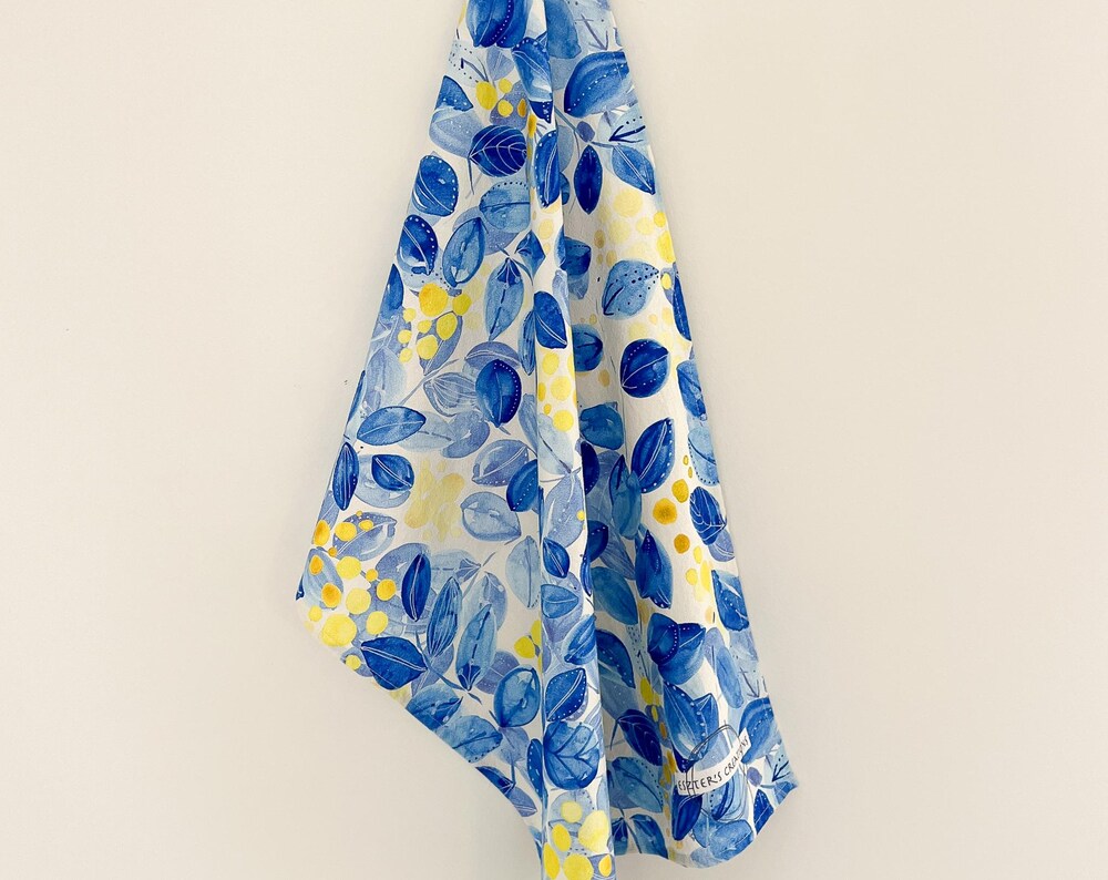 Australian unique cotton teatowel featuring Blue leaves and yellow berries in watercolor art.