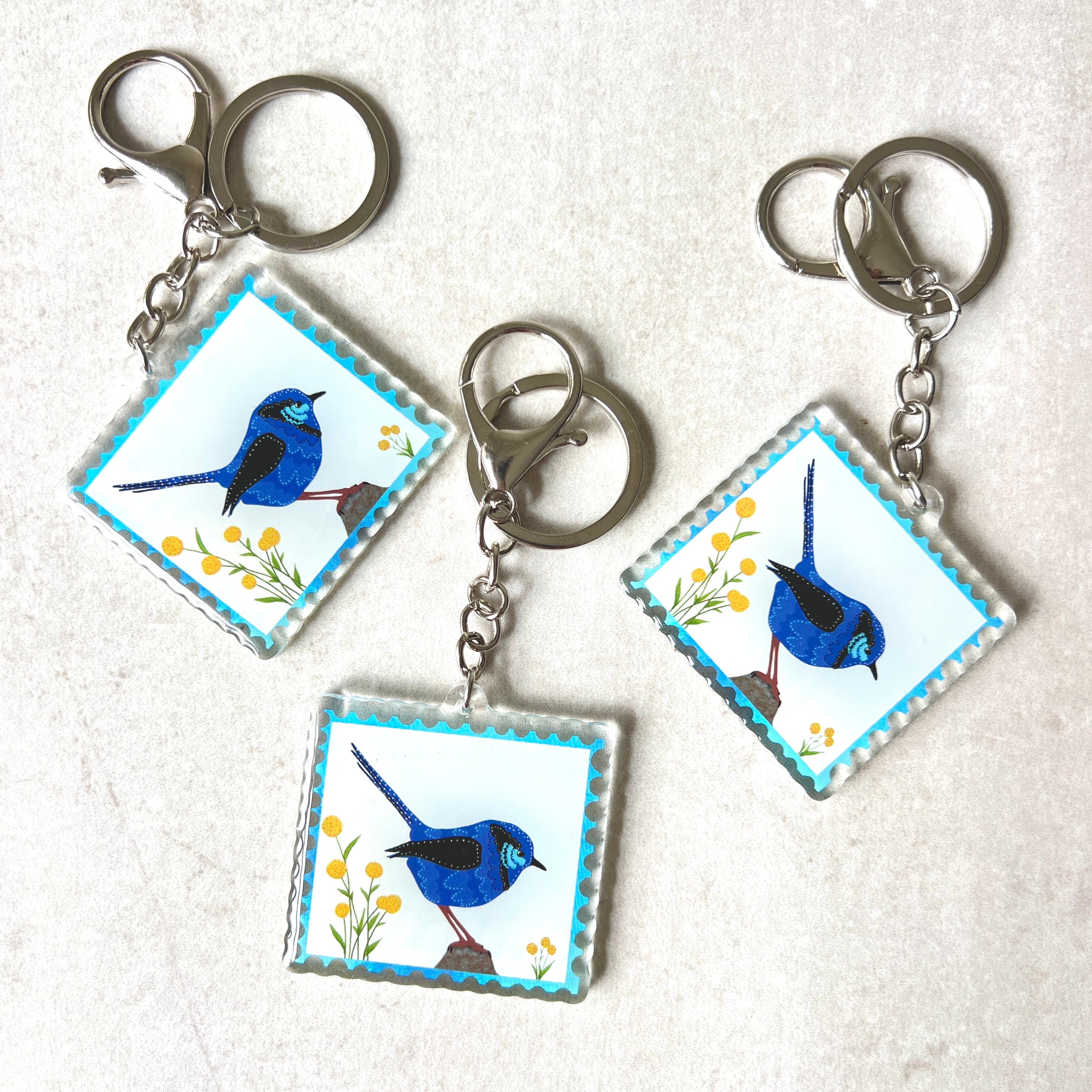 Blue wren acrylic keychain with vibrant Australian bird design on white marble surface - native wildlife souvenir gift