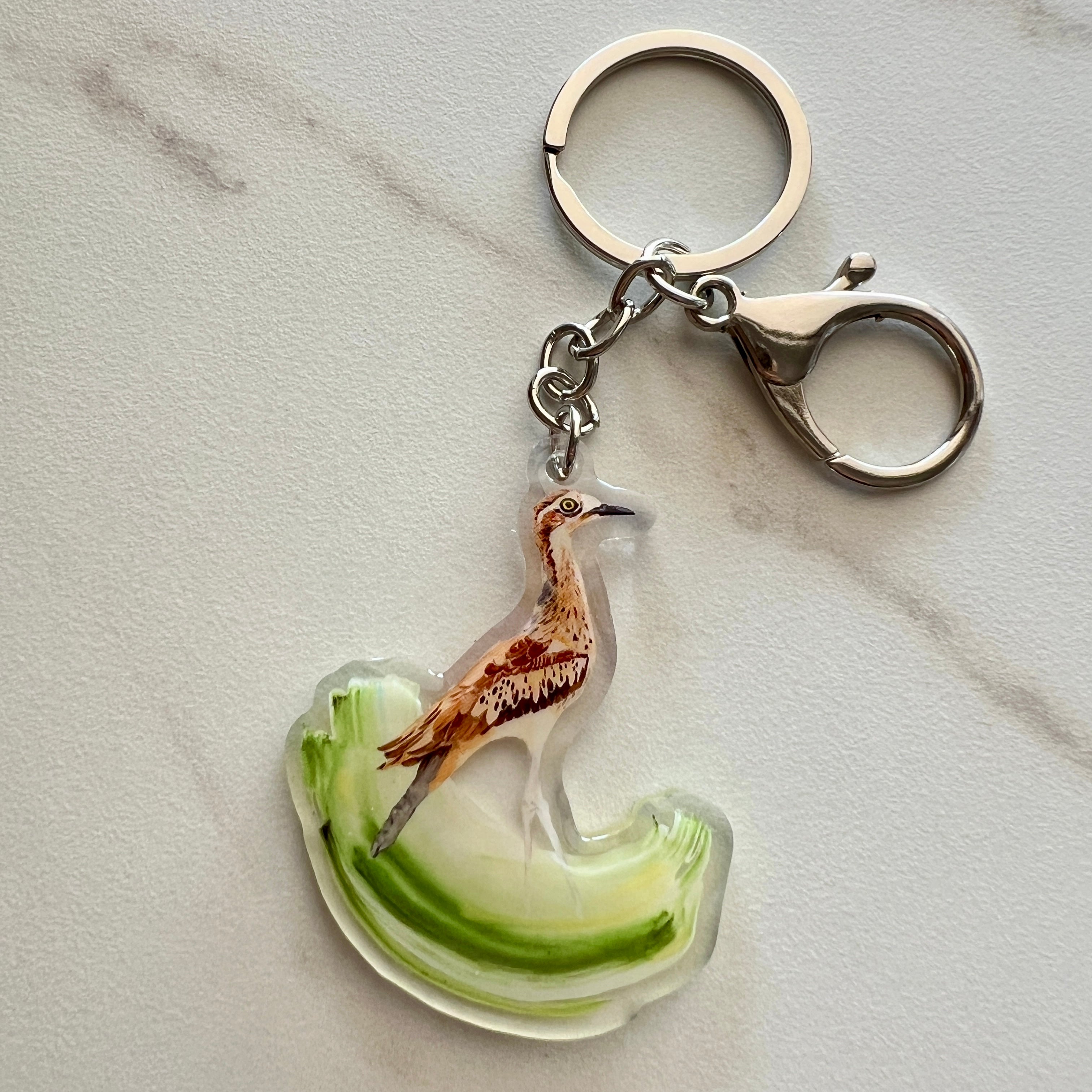 Keychain with a curlew design on a light gray background