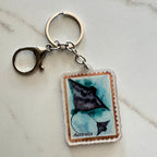 Keychain with a stingray design on an Australian postage stamp, on a light gray background.