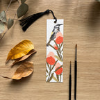 Bookmark with banksia and honey eater design on a wooden surface with leaves and paintbrushes.