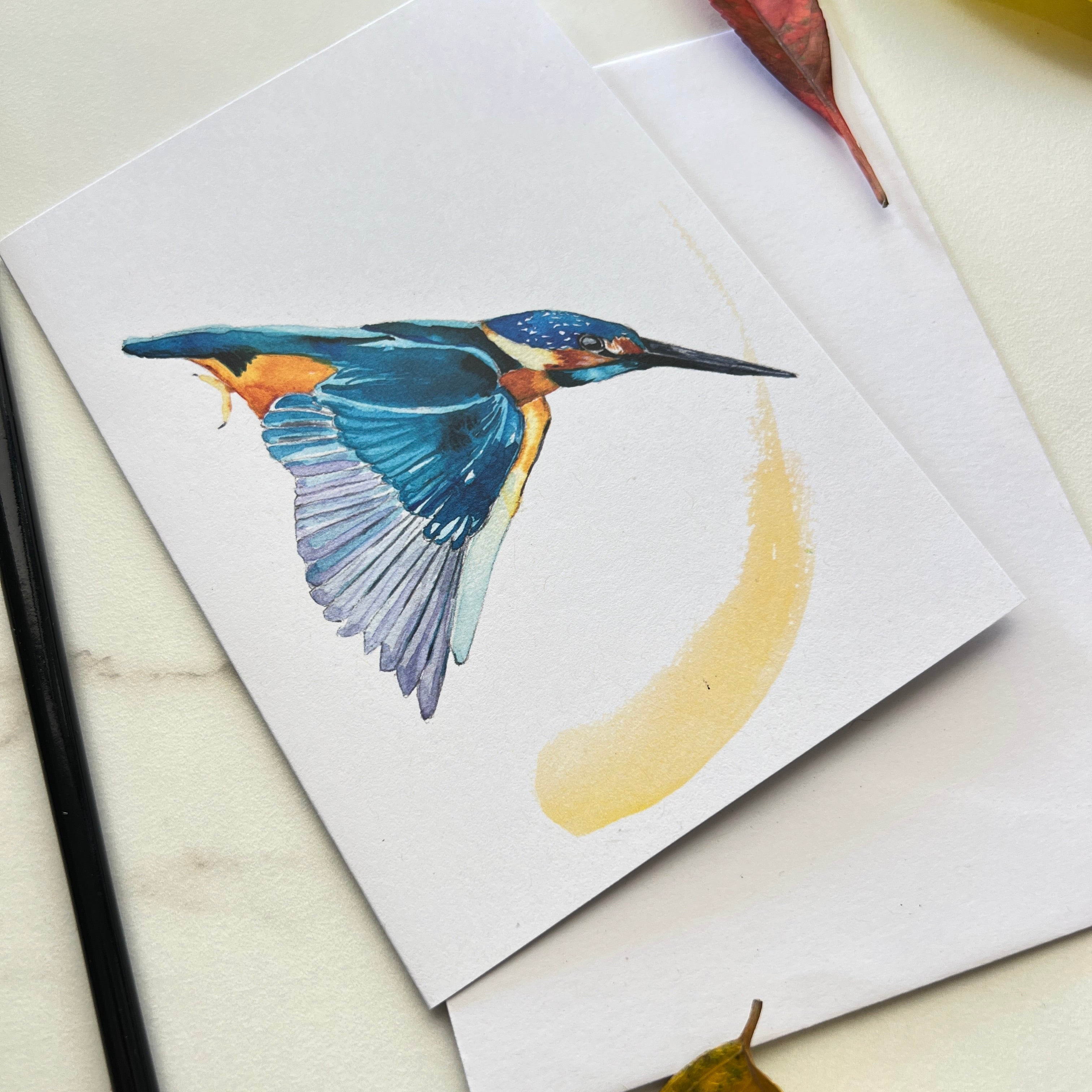 Card with a kingfisher bird illustration on a white surface