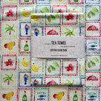 Beautiful soft cotton teatowel that reminds you of a tropical holiday, featuring bananas, mangoes, palm leaves, hibiscus, sunbrella, palm tree.