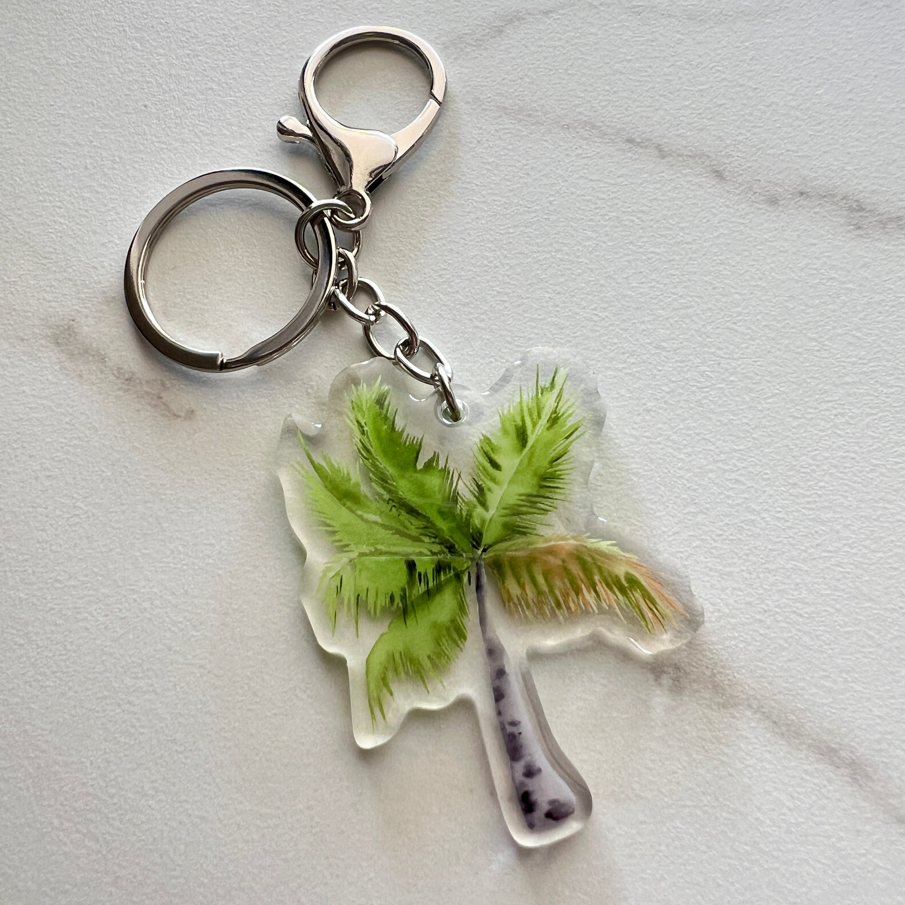 Keychain with a port douglas palm tree design on a light gray background