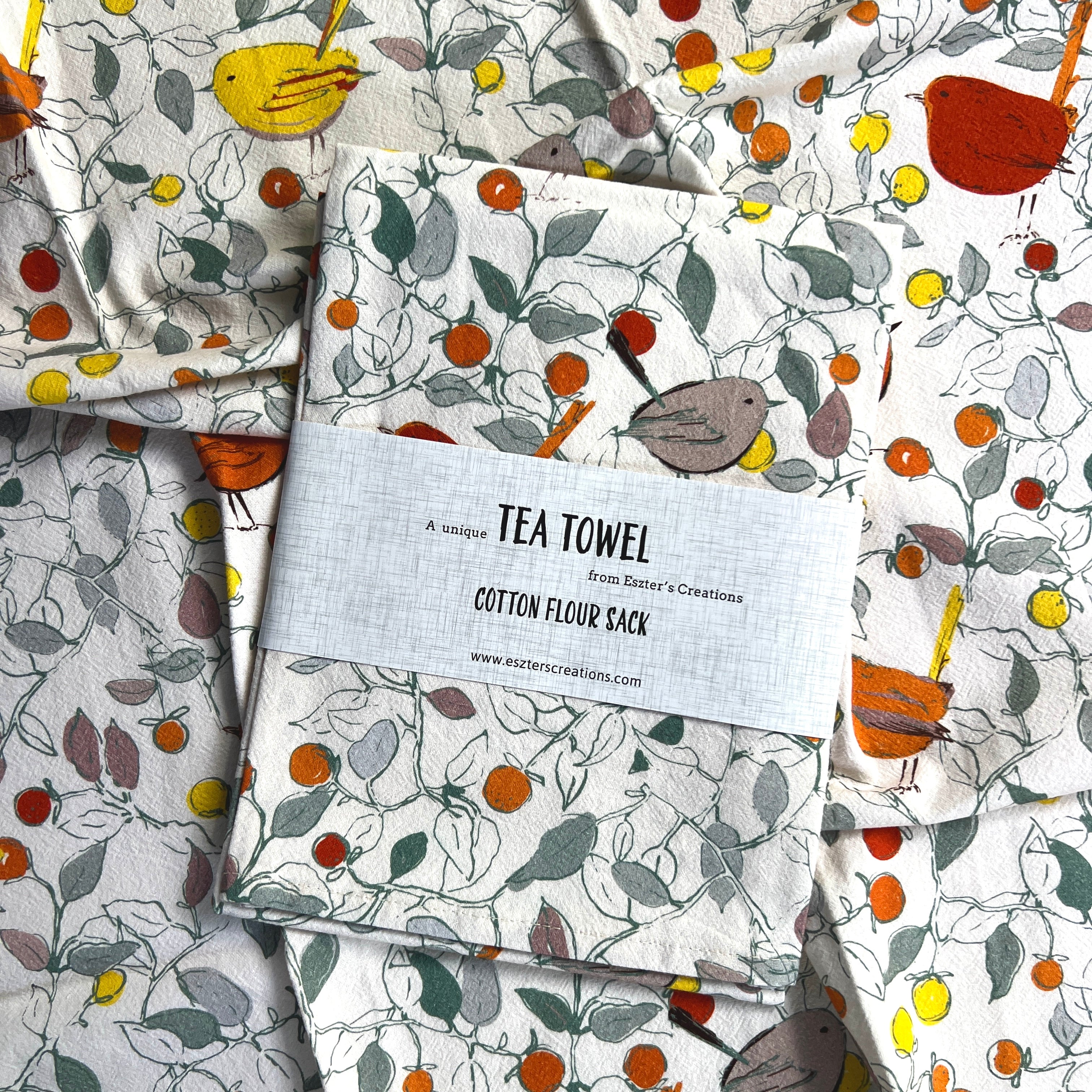 artistic birds tea towel in autumn colours in woodland setting