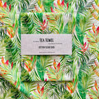 Tea towel with tropical leaf pattern and beautiful heliconia flowers.