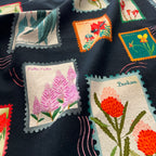 vibrant Australian wildflower stamp tea towel on black background, cotton flour sack kitchen towel by Eszter Torok