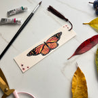 monarch Butterfly bookmark with art supplies on a marble surface